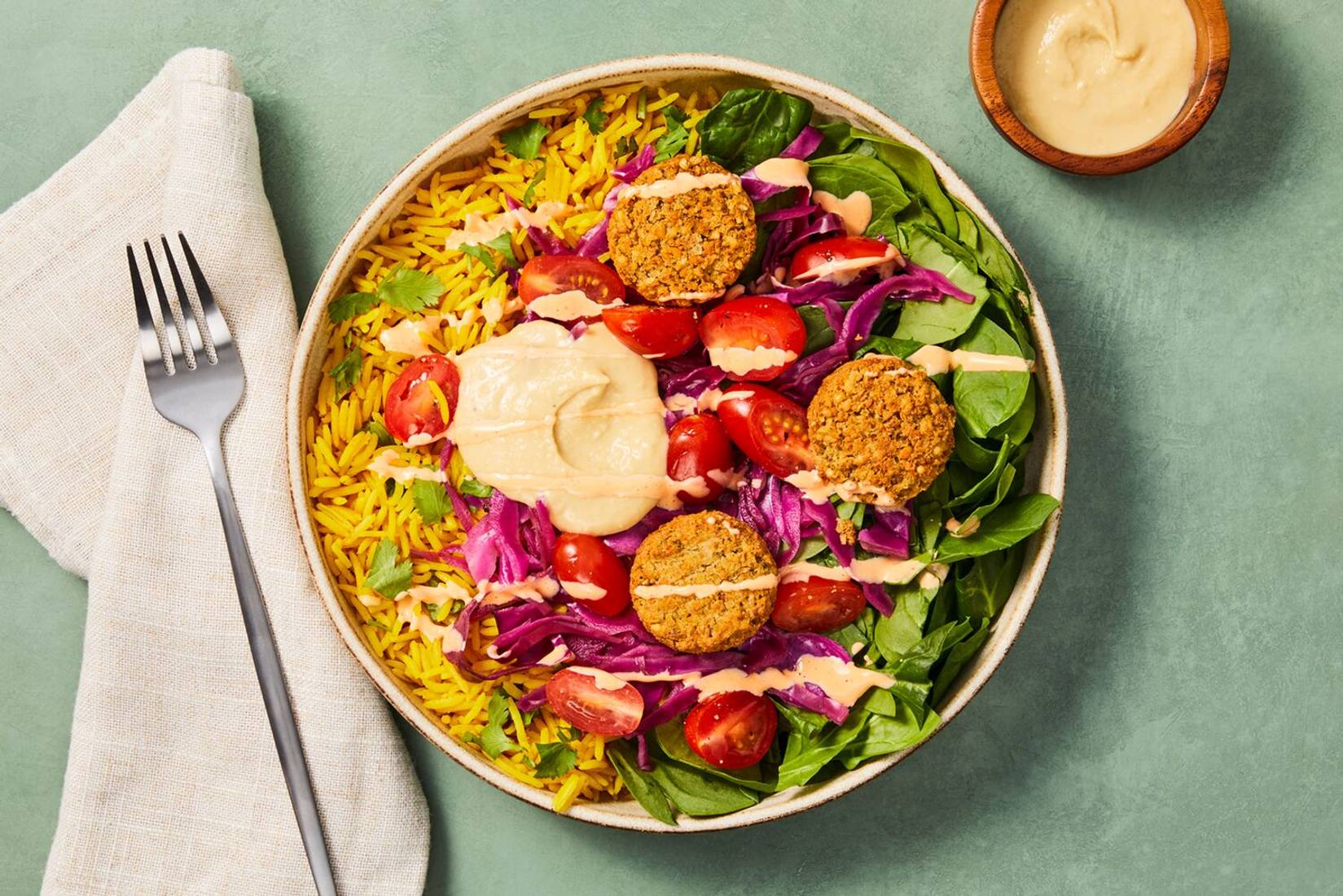 Bols de poitrines de poulet, de falafels et de riz au curcuma