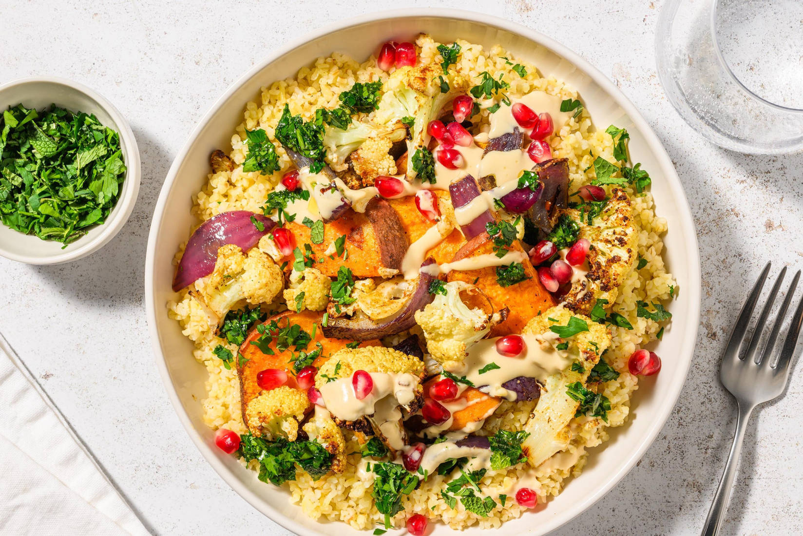 Légumes rôtis garnis de grenade et houmous