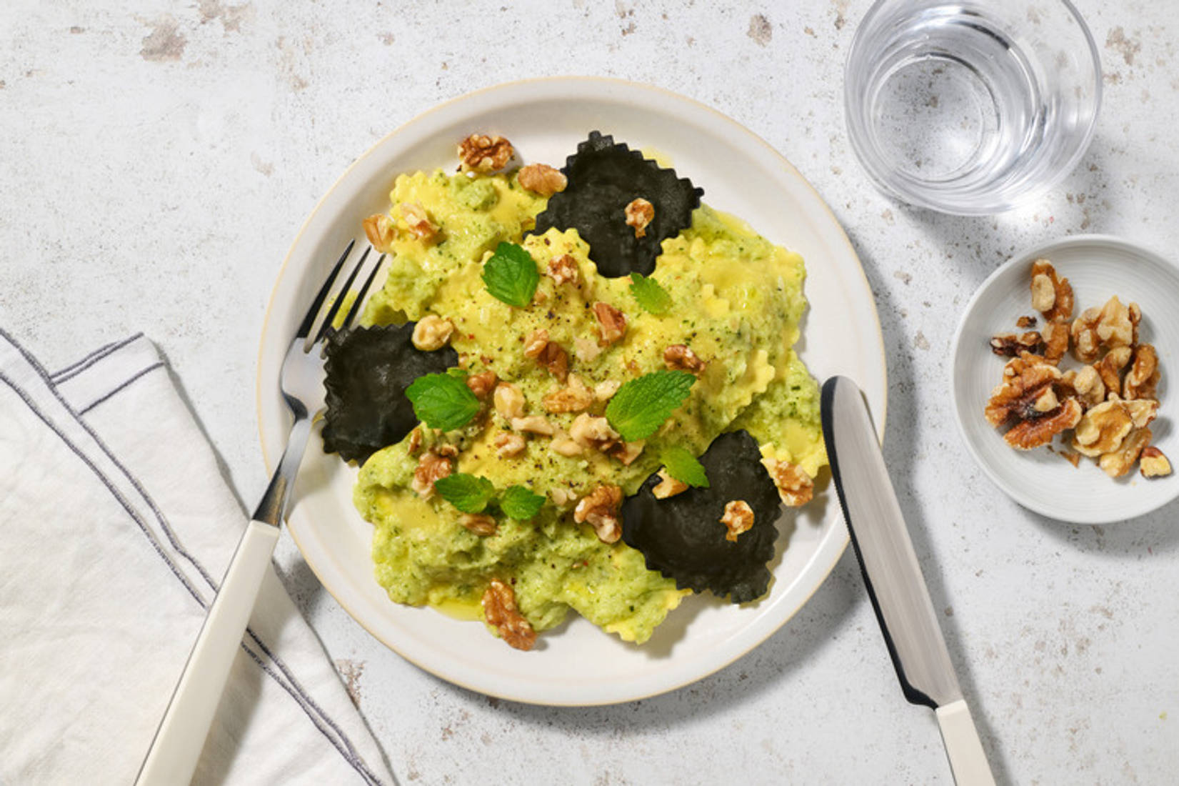 Ravioli di nasello bicolore in crema di zucchine