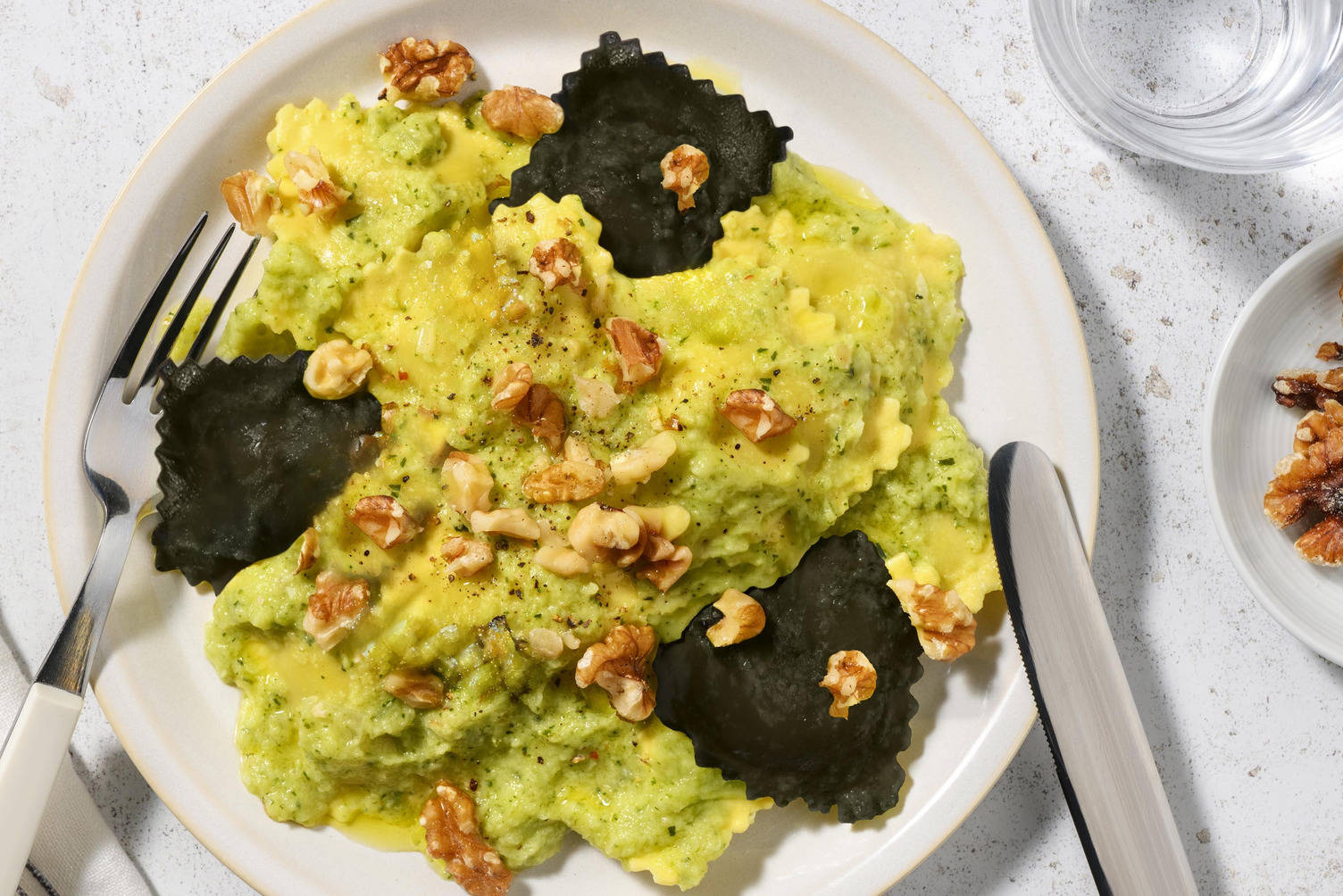 Ravioli di nasello bicolore in crema di zucchine