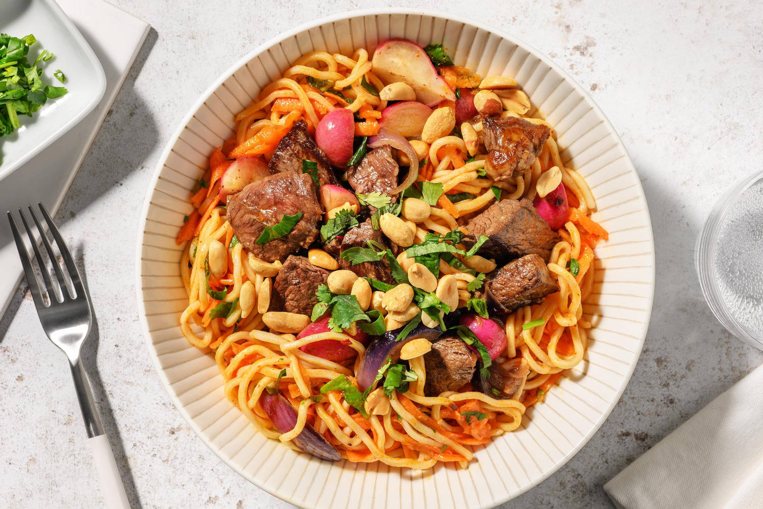 Salade de nouilles aux émincés de steak, herbes fraîches et cacahuètes