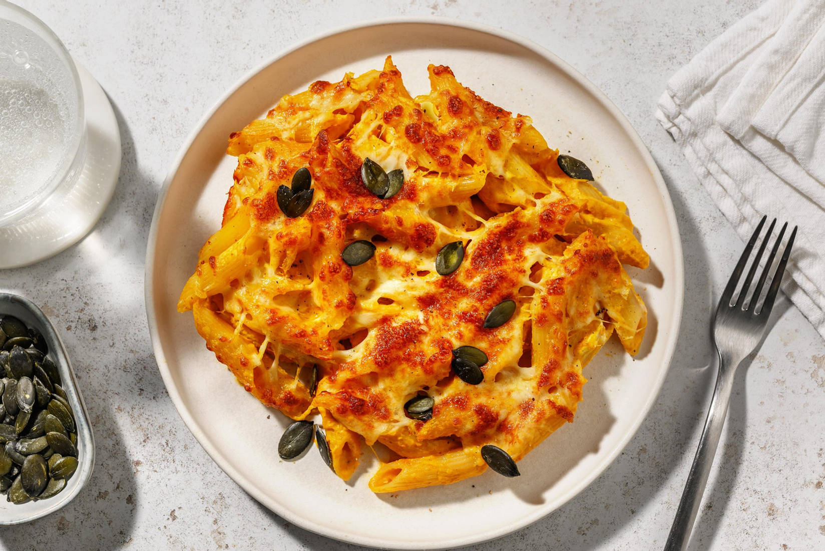 Gratin de pâtes garni de graines de courge