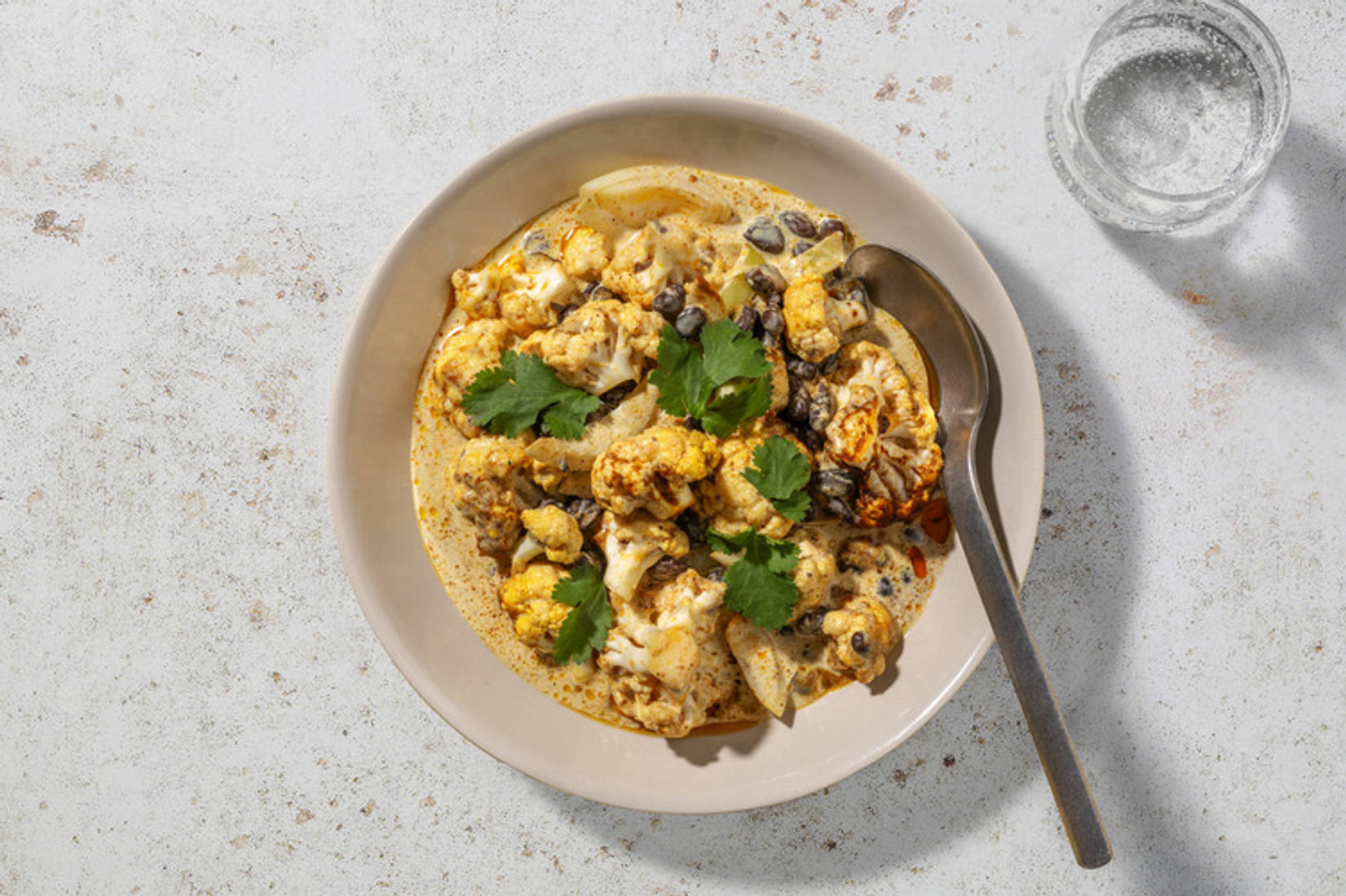 Curry cremoso de langostinos y coliflor asada y alubias
