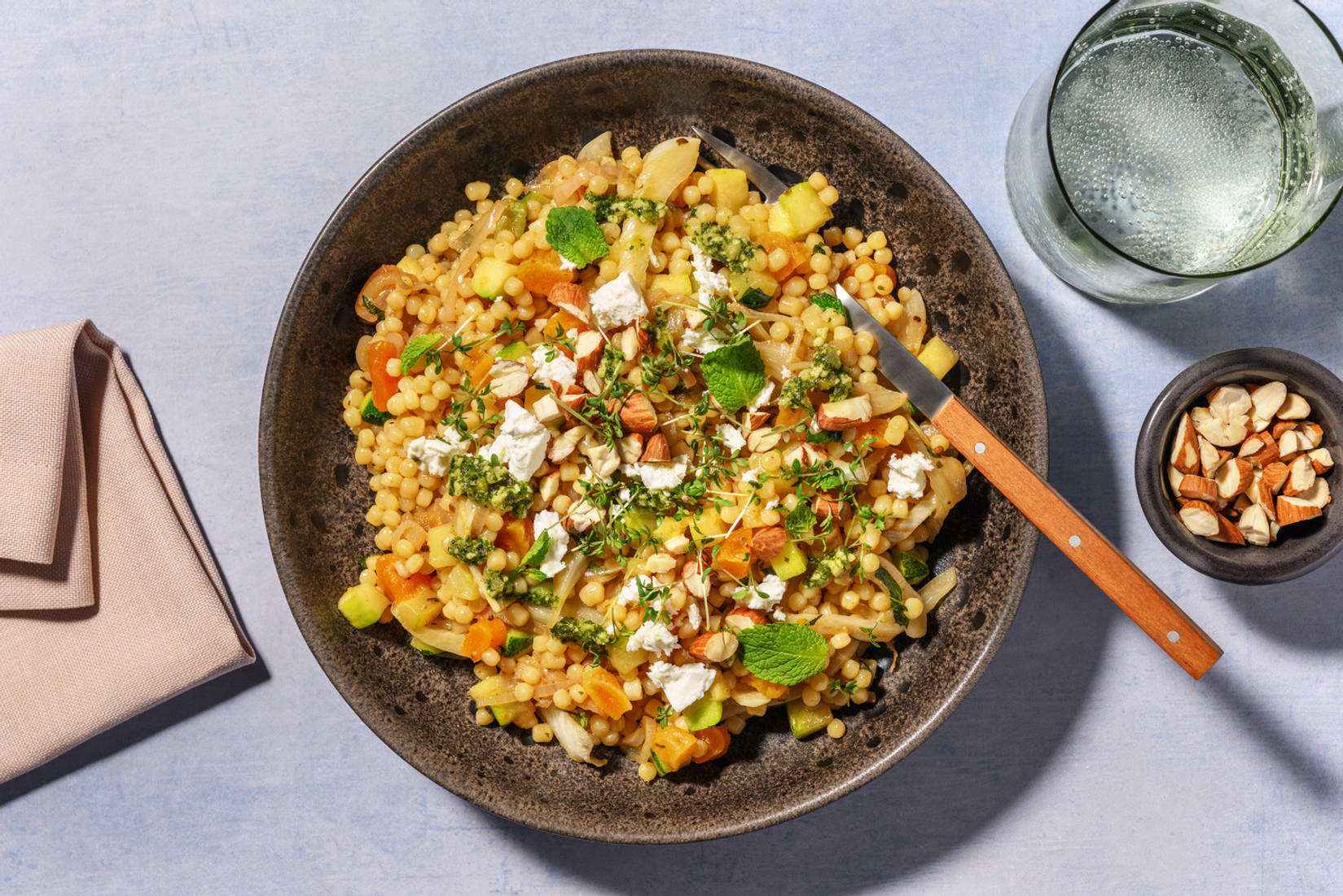 Parelcouscousbowl met munt, feta, zhoug en amandelen