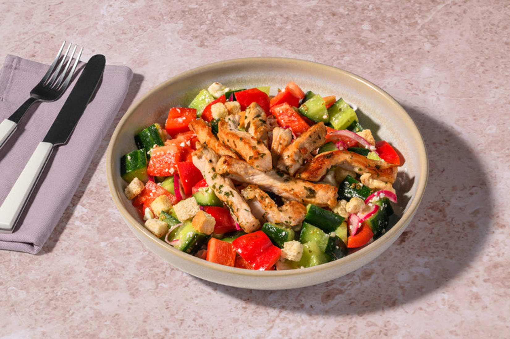 Bio-Schweinefleischstreifen auf griechischem Salat