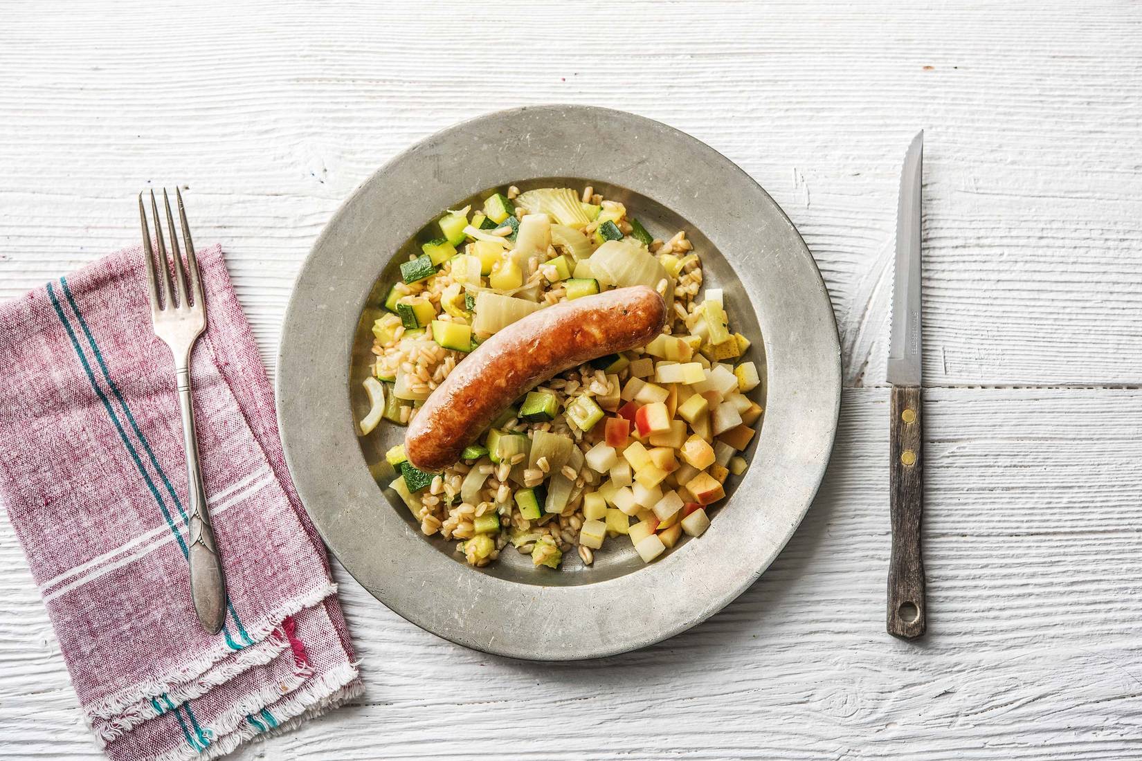 Toulouse varkensworst in appelcidersaus met parelgerst en gebakken fruit