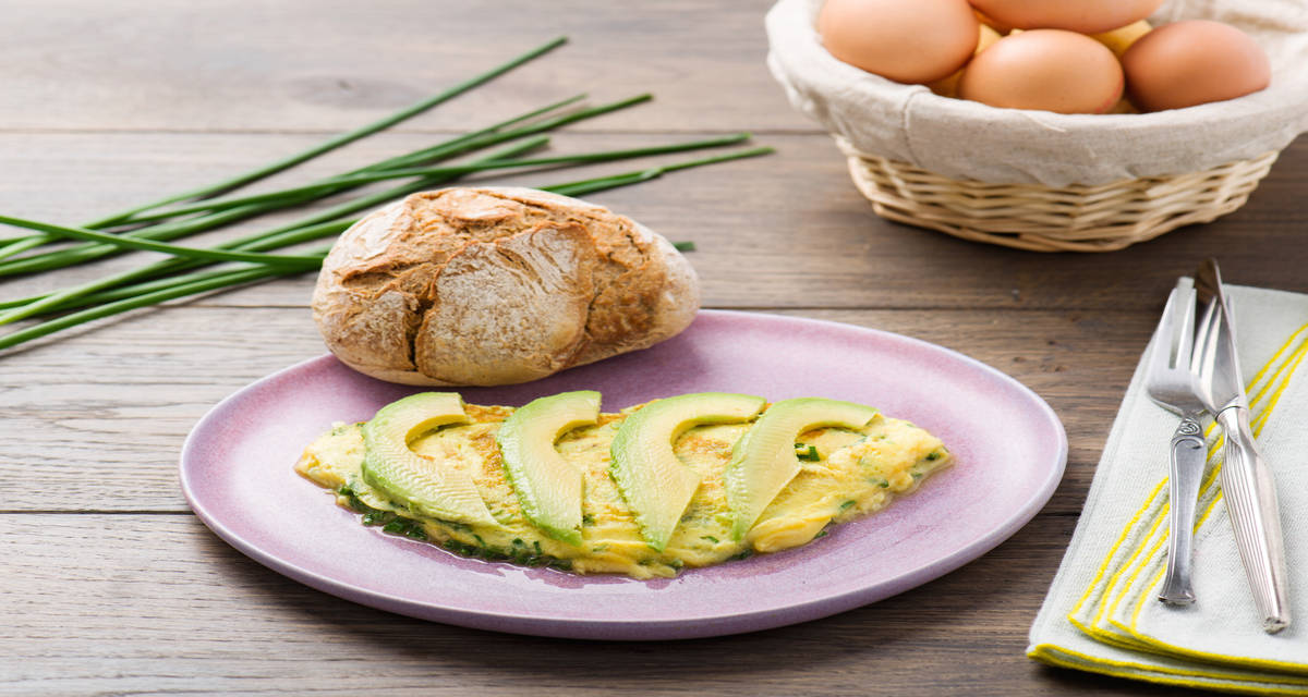 Omelette accompagnée d'avocats et de pain brun