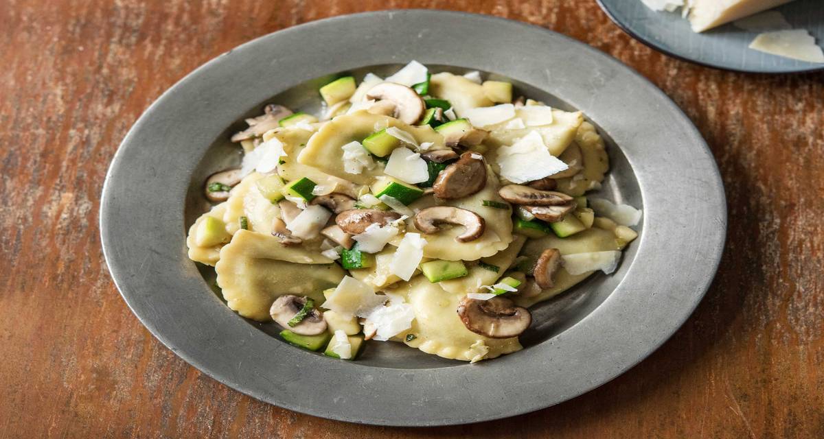 Raviolis frais à la truffe et à la ricotta servis avec du fromage vieux Aux champignons blonds et à la courgette