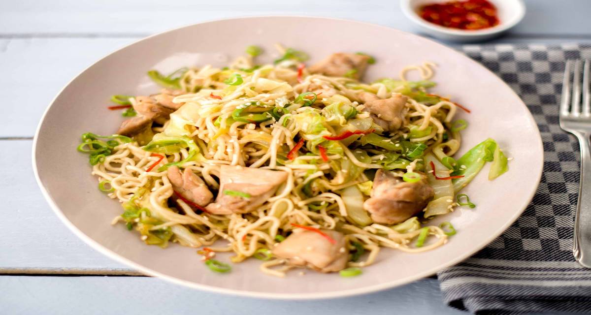 Poulet aux nouilles, chou pointu et graines de sésame Avec du piment rouge, de jeunes oignons et de la sauce soja