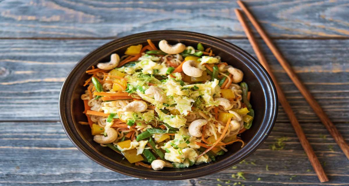 Nouilles asiatiques, mélange de légumes, jeunes oignons, œuf et noix de cajou Aux jeunes oignons et au jus de citron vert