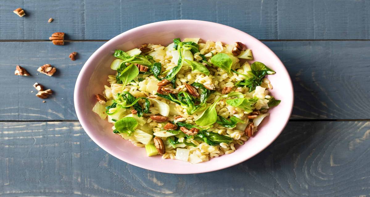 Risotto d’orge perlé au fenouil et au fromage de chèvre Avec des noix de pécan et de la mâche