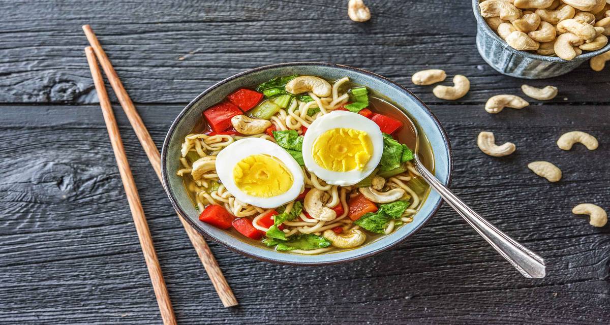 Soupe orientale de nouilles Avec des nouilles, du pak-choï, des noix de cajou et un œuf