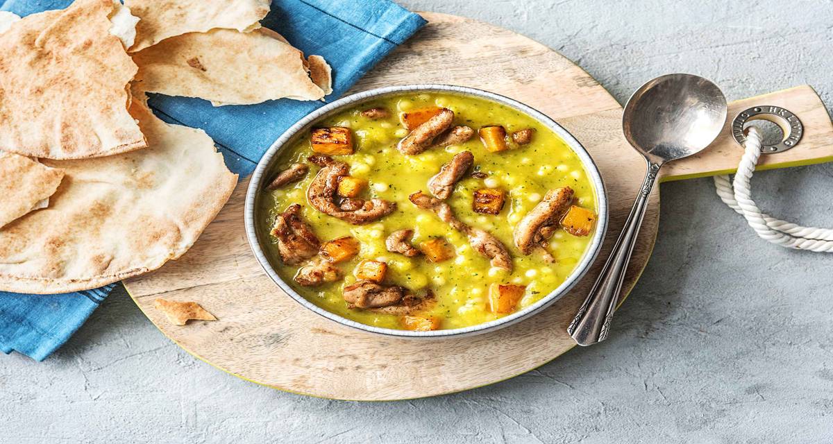 Soupe turque avec du poulet au ras-el-hanout Avec du couscous perlé, de la courge, de la courgette et du romarin