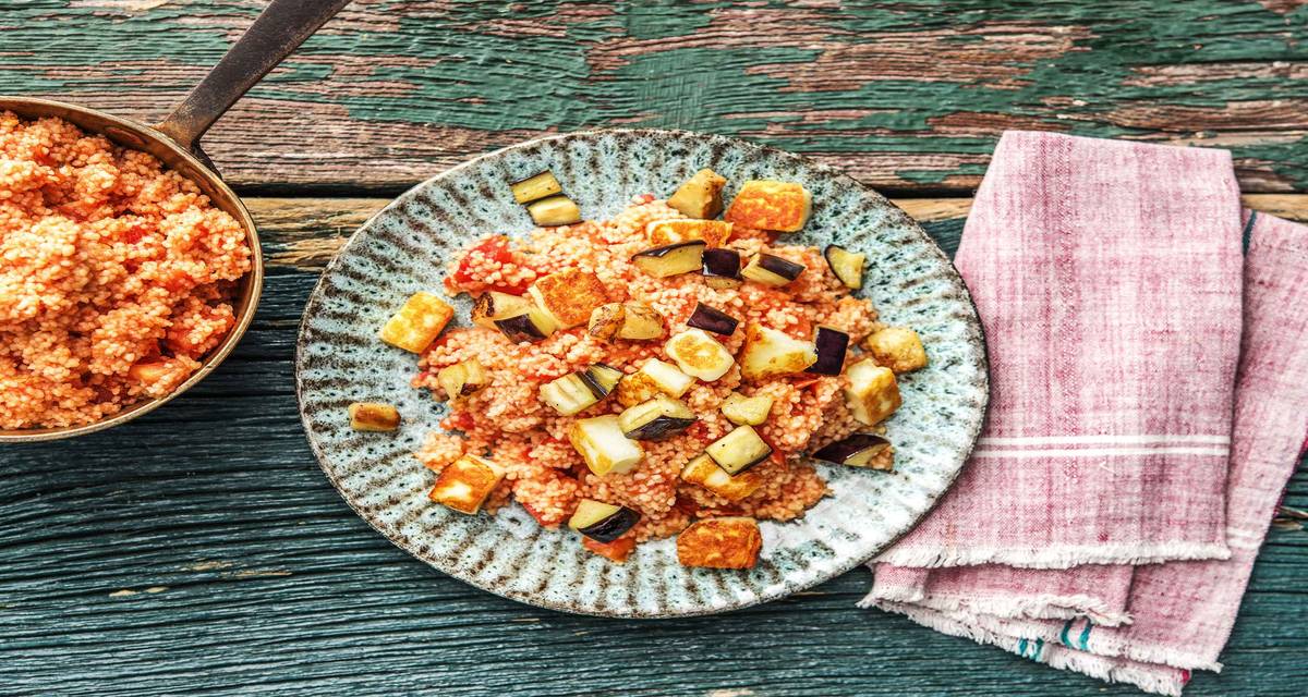 Couscous complet aux tomates Avec du paneer cuit, de la harissa piquante et de l’aubergine