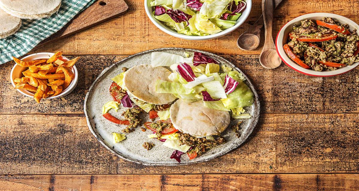 Pains pita italiens au hachis de boeuf Avec une salade de tomates au pesto, des patates douces et de l’iceberg croquante