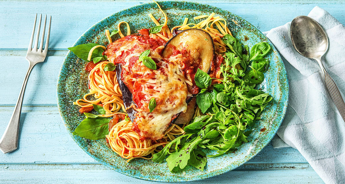 Aubergine au four à la tomate et au fromage Avec des fettuccine et une salade tout en fraîcheur