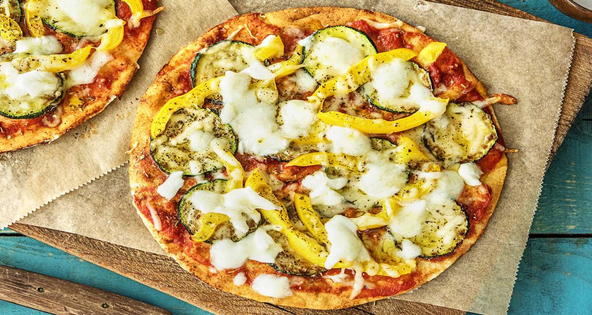 Pizza à l’italienne sur pain plat avec de la mozzarella de bufflonne Avec de la courgette et du poivron jaune