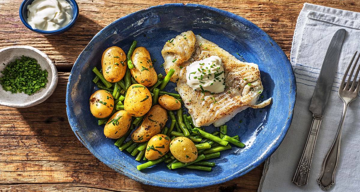 Filet d'églefin et grenailles à l'ail Avec des haricots verts, des herbes fraîches et de la crème aigre