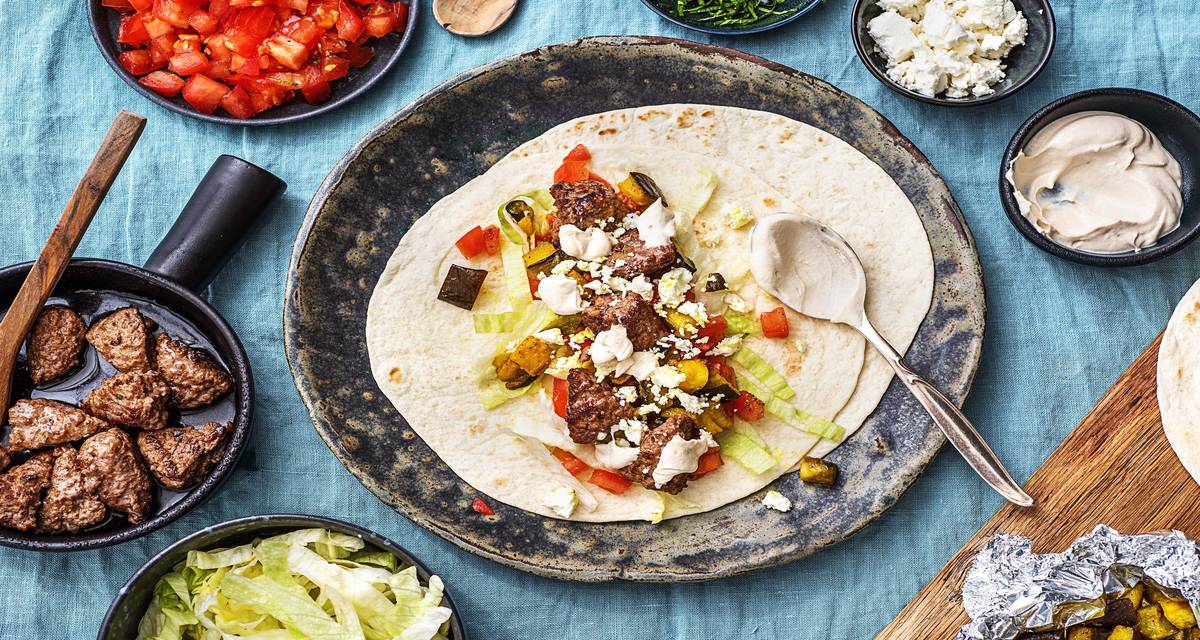 Wraps à l’aubergine épicée et au steak haché Avec de la feta, de la menthe et une sauce au yaourt et au tahini