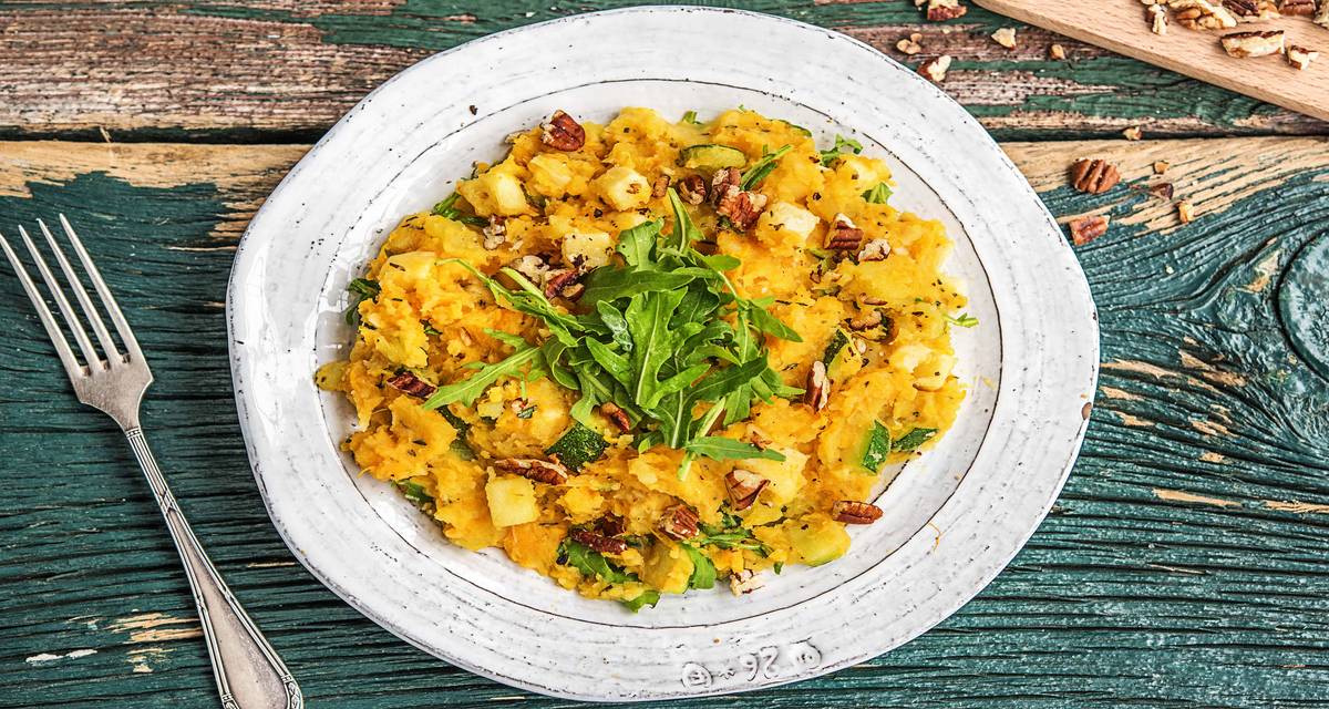 Purée de panais et de patates douces Avec de la roquette, des noix de pécan et des dés de fromage aux herbes