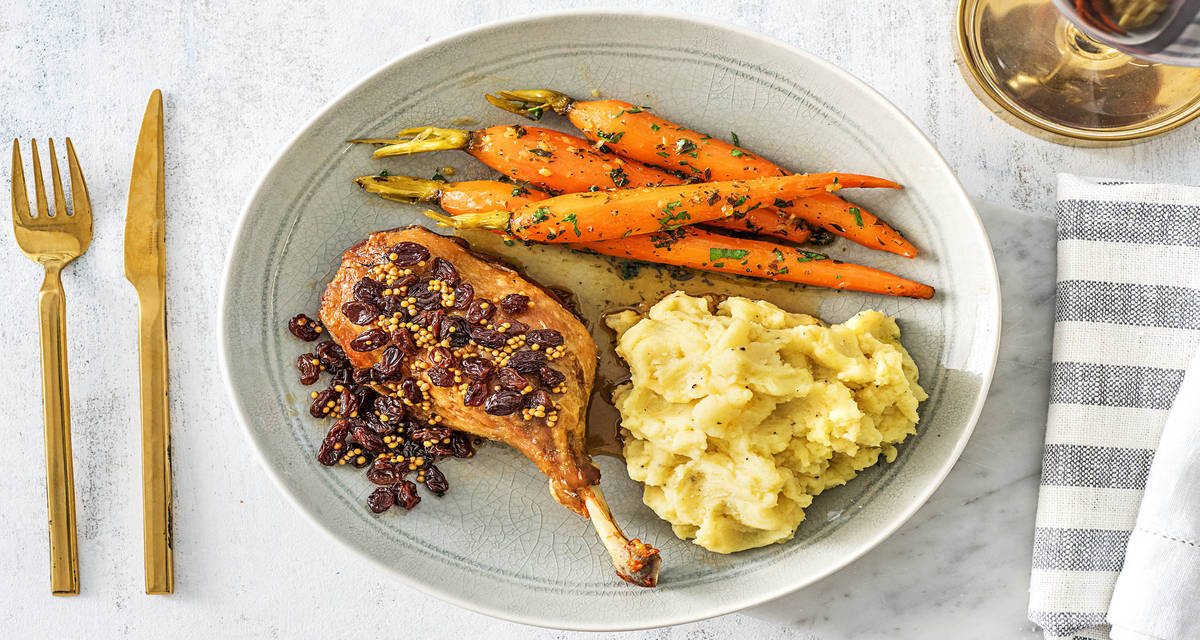 Cuisse de canard confite et raisins secs Avec des carottes glacées et une purée de pommes de terre