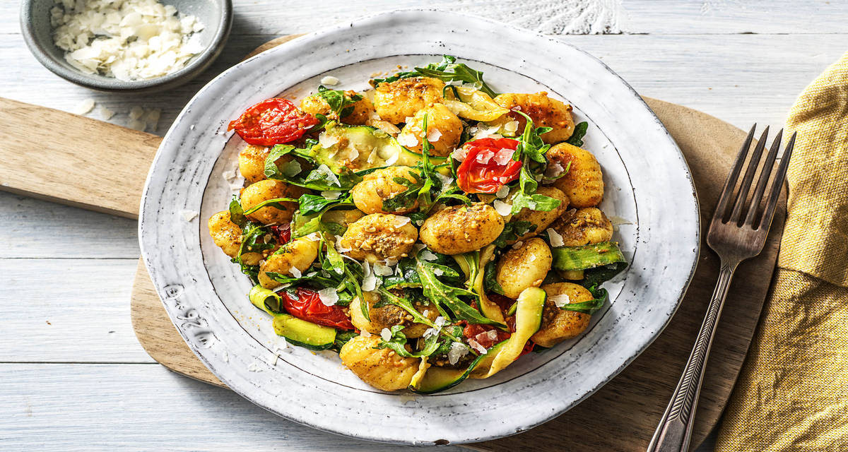 Gnocchi poêlés au pesto vert Avec des lamelles de courgette, de la roquette et des tomates cerises
