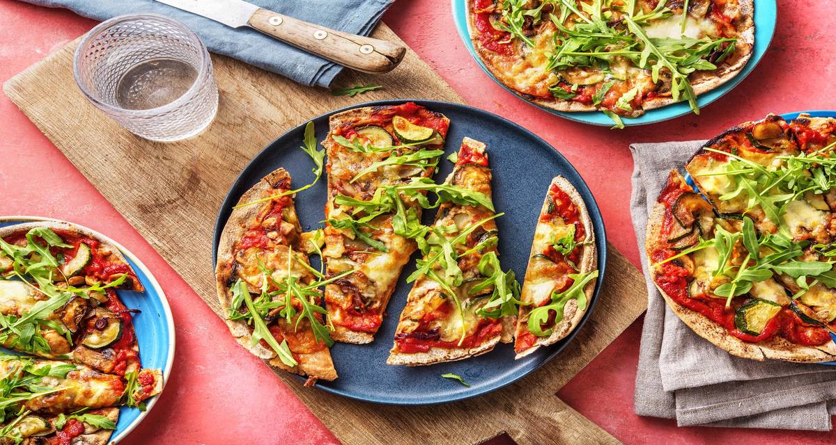 Pizza funghi sur pain plat à la mozzarella de bufflonne Garnie de courgette et de roquette