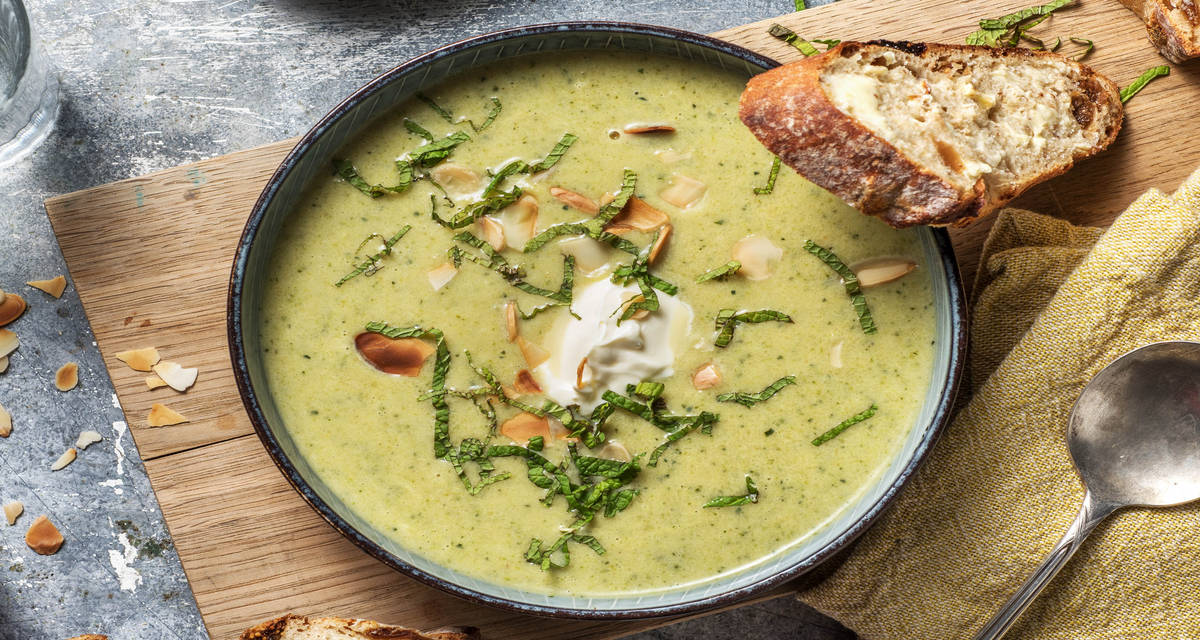 Velouté de brocoli et crème fraîche Servi avec des amandes effilées et de la menthe fraîche