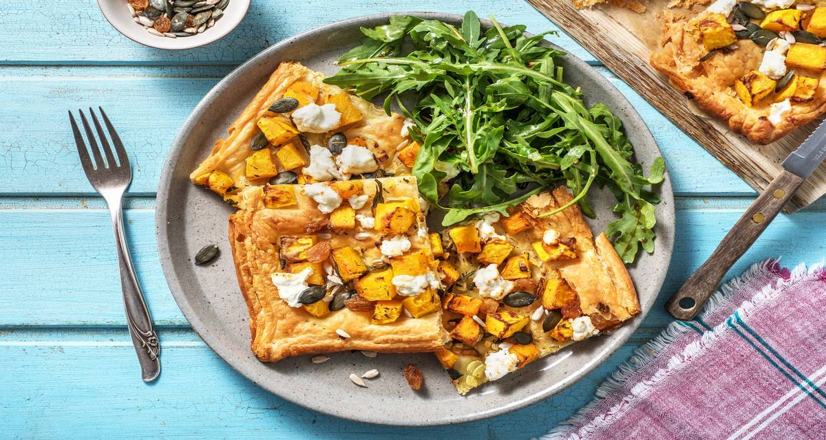 Tarte fine à la courge et au chèvre Accompagnée de roquette et garnie de graines de courge