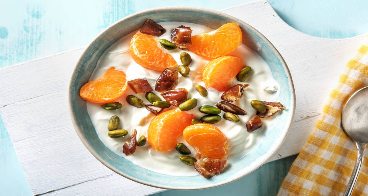 Fromage blanc au lait entier avec de l'orange avec des pistaches et des dattes