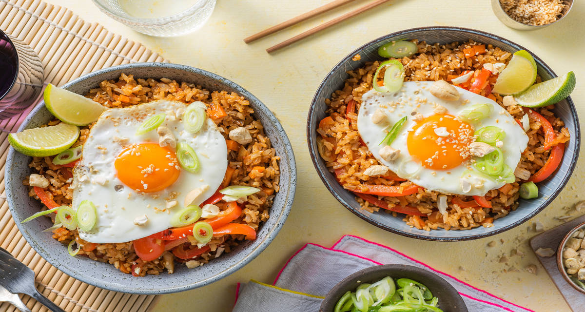 Légumes asiatiques sautés agrémentés de noix de cajou servis avec du riz et un œuf au plat