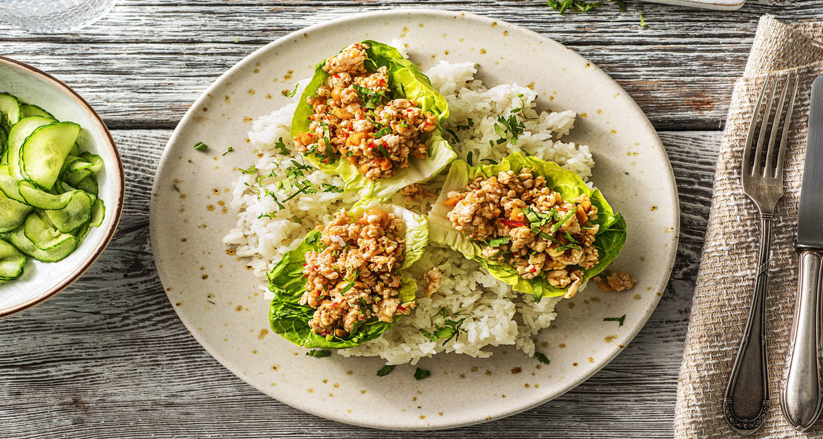 Salade thaïlandaise de poulet haché piquant servie dans de la little gem avec des concombres aigres-doux