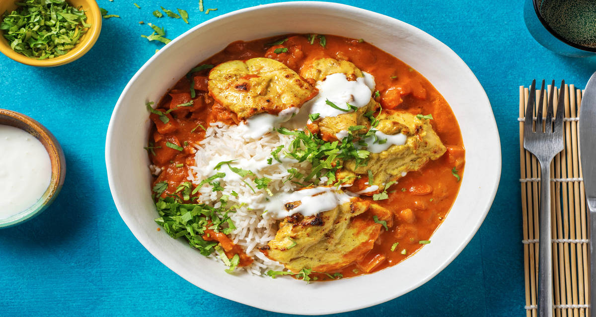 Poulet tikka masala au yaourt servi avec du riz, de la coriandre fraîche