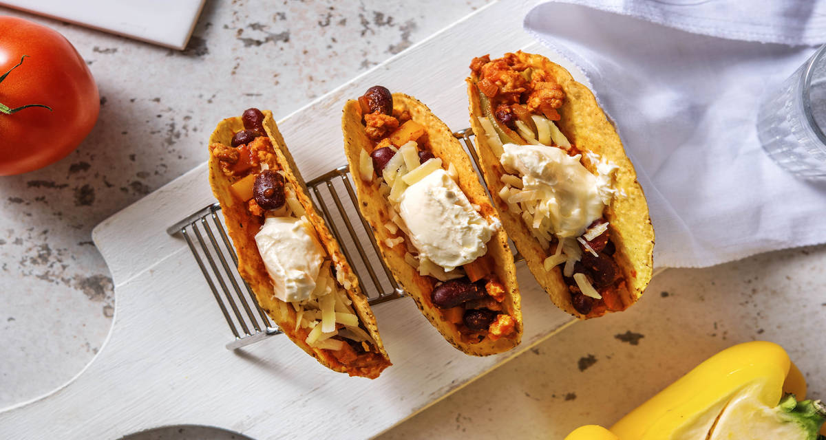 Tacos mexicains au poulet haché accompagnés de piment rouge et cheddar