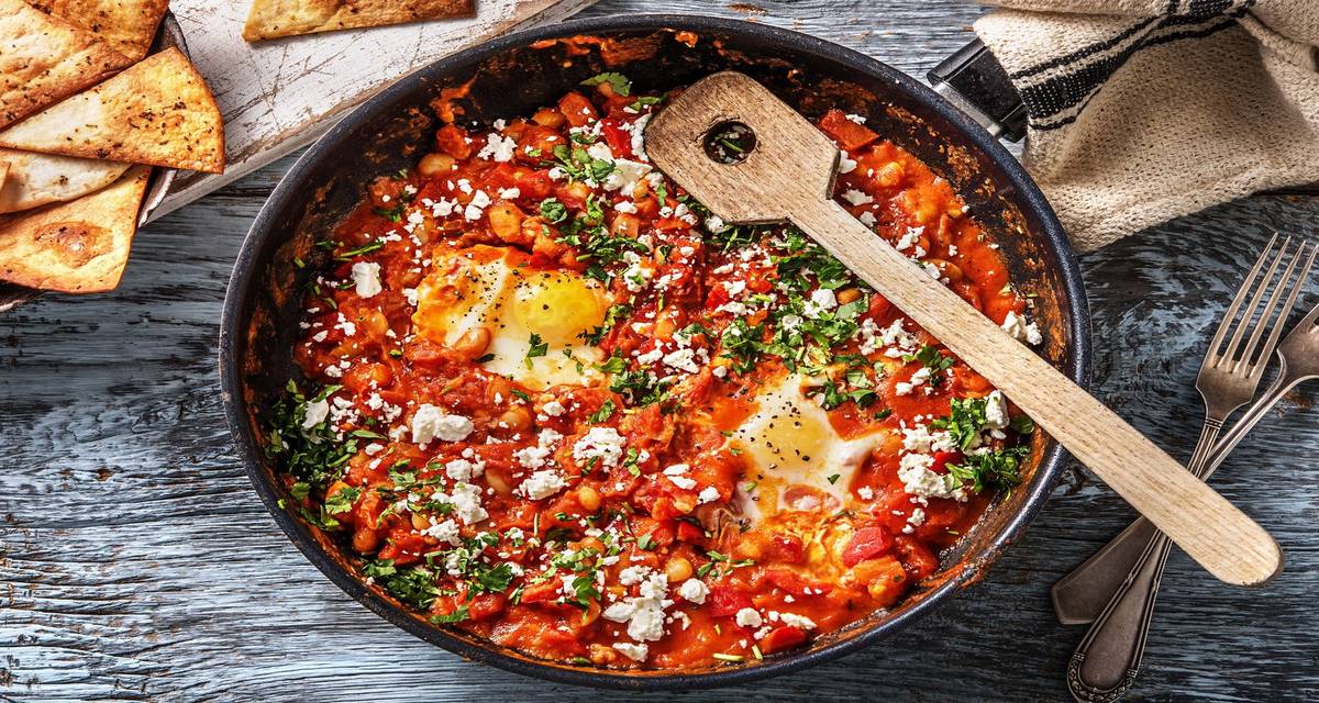Chakchouka à la mexicaine et chips de tortilla maison garnie de tomate, haricots cannellini, feta et œuf