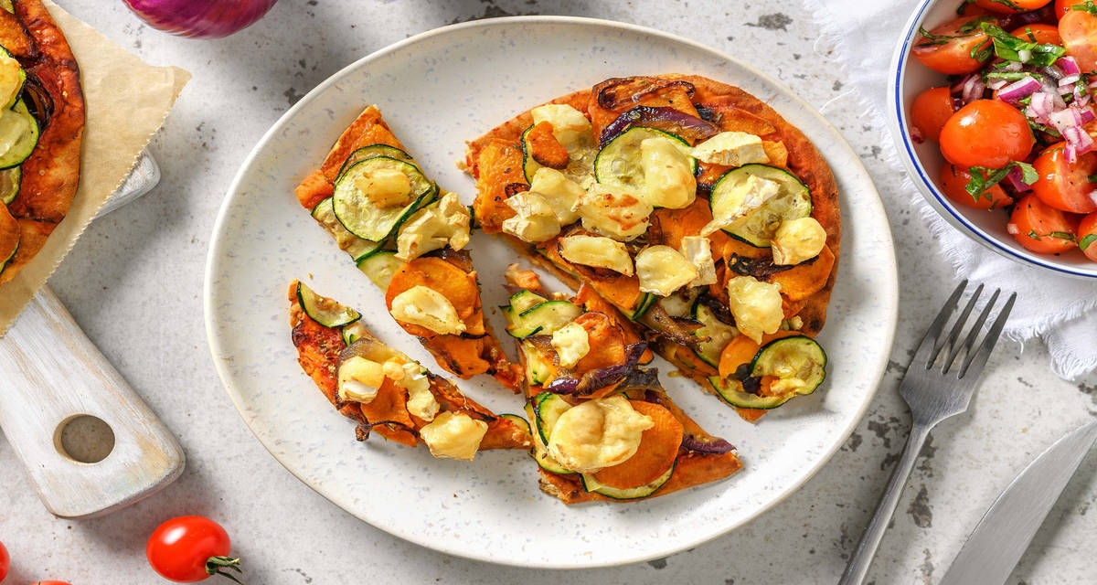 Pizza sur naan au chèvre et aux légumes accompagnée d’une salade de tomates