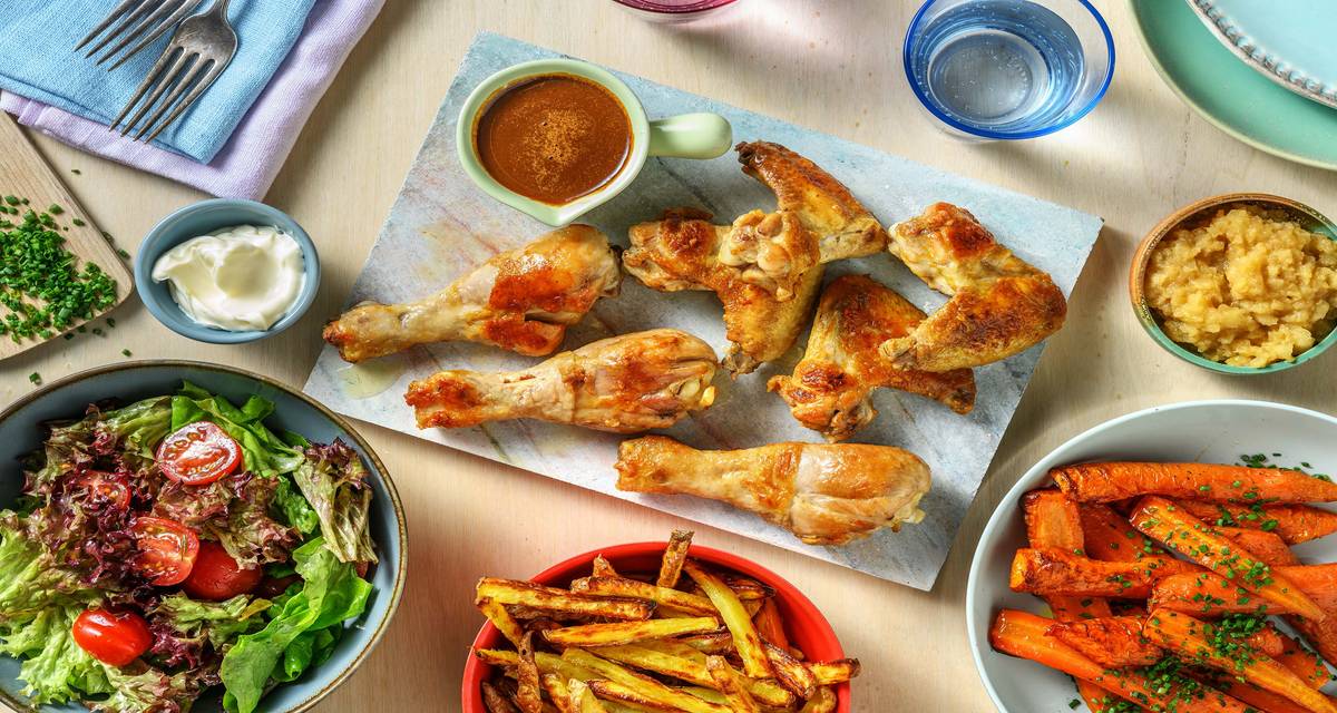 Poulet, frites au four et compote de pomme servis avec des carottes et une sauce à la cacahuète
