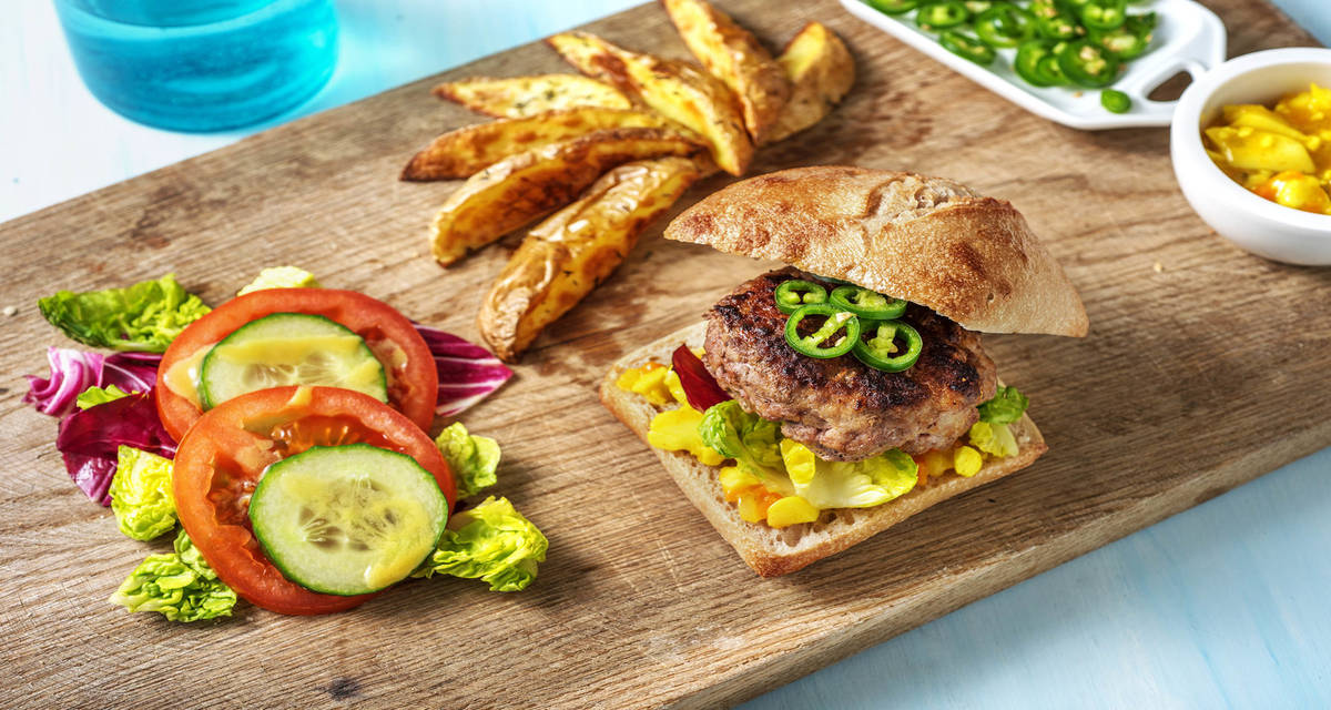 Burger met pittige groene peper en piccalilly met aardappelpartjes en salade