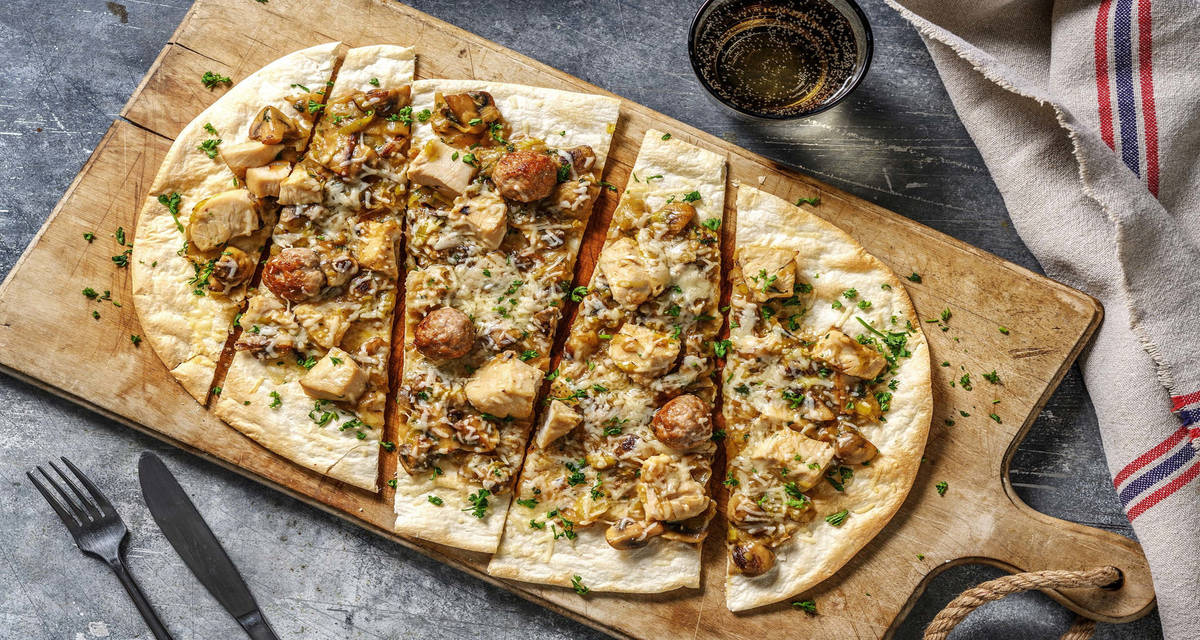 Flammekueche sauce vol-au-vent garnie de poireau, champignons et fromage italien