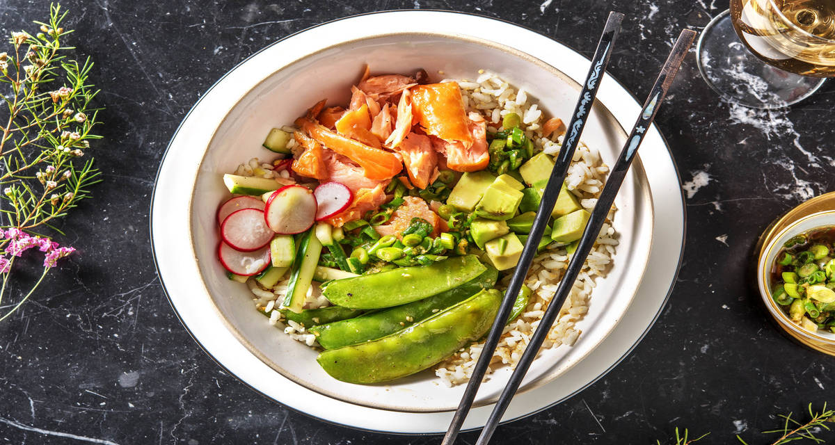 Sushi bowl au saumon fumé à chaud accompagné de radis et de concombre marinés et d'avocat