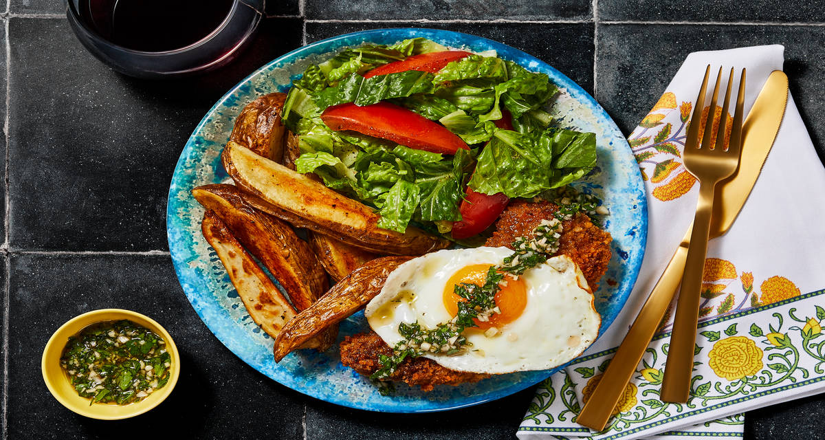 Argentinean-Style Beef Milanesa with Roasted Potatoes, Fried Eggs, Chimichurri & Salad