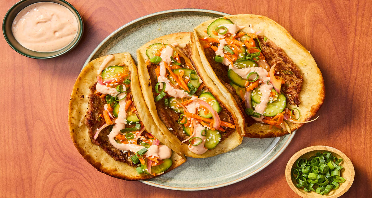 Smashed Pork Gyoza Tacos with Pickled Veggies, Sriracha Mayo & Sesame Seeds