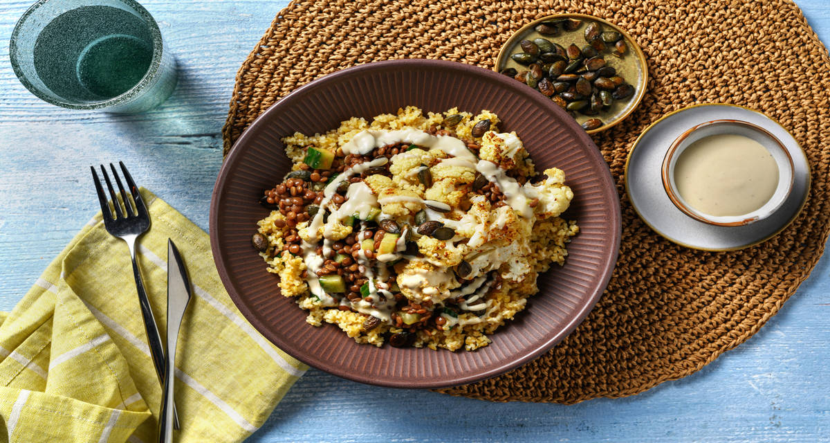 Bowl met zoete aardappelpuree en geroosterde bloemkoolsteaks met linzen-mangochutney en hummus-dressing