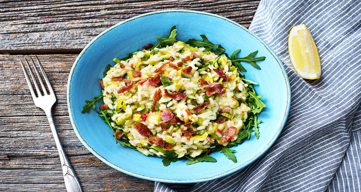 Risotto épicé au poireau & poitrine fumée servi sur un lit de roquette avec du pecorino
