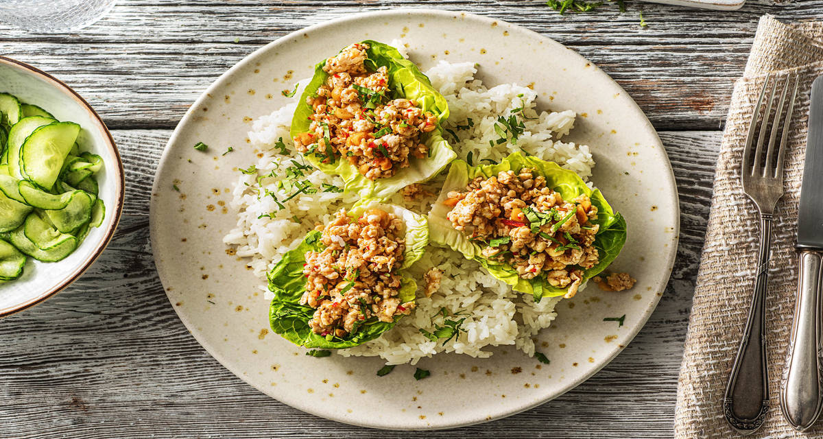 Salade thaïlandaise de poulet haché piquant servie dans de la little gem avec des concombres aigres-doux