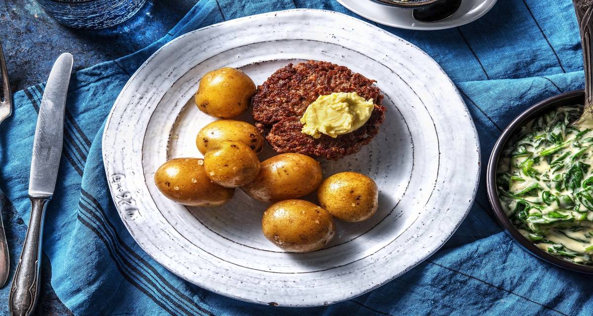 Steak haché et beurre au citron vert accompagné d'épinards et de grenailles