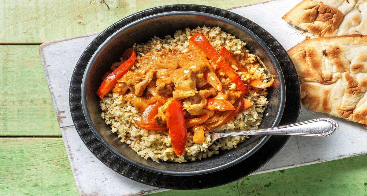 Curry de poulet express & riz de chou-fleur servi avec un naan et du poivron rouge