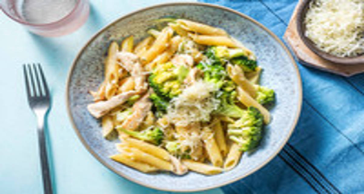 Pâtes au poulet façon Alfredo servies avec des brocolis et du fromage italien