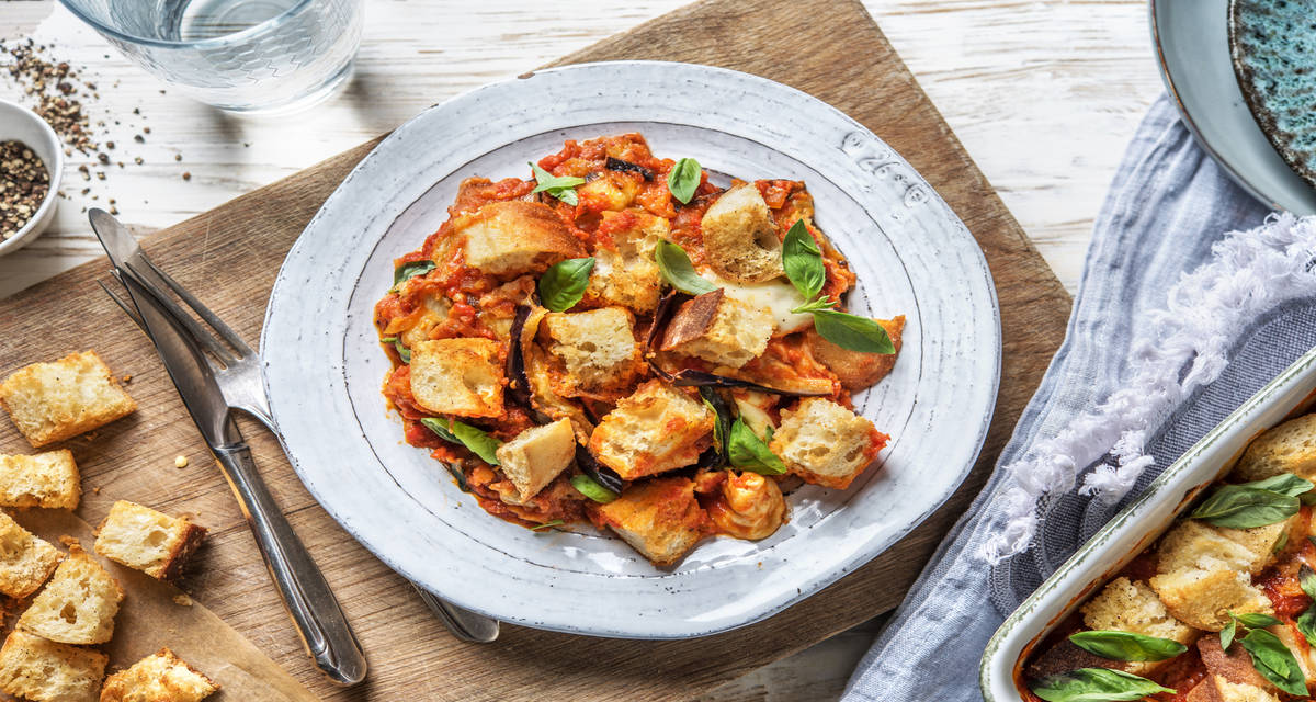 Berenjena a la parmigiana con mozzarella, salsa de tomate y picatostes caseros