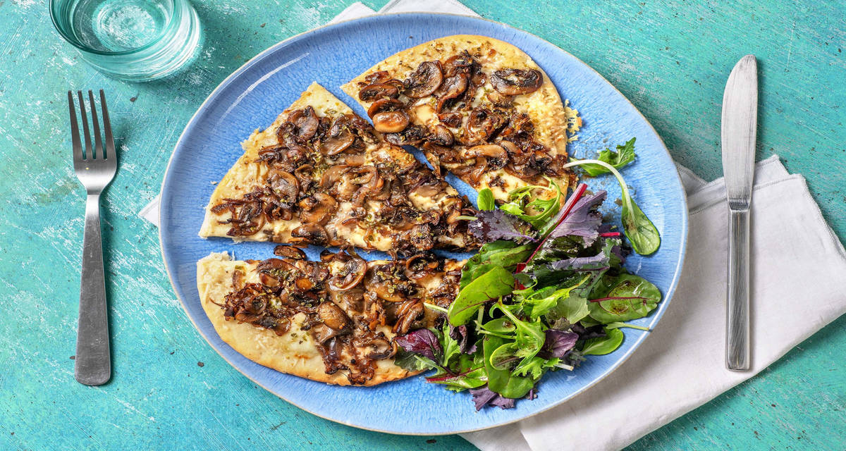 Pizza bianca aux champignons sur pain naan avec de l'origan et de l'ail